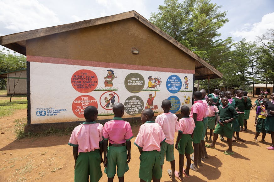 Families versterken Busia Kenia kinderrechten op muren van school