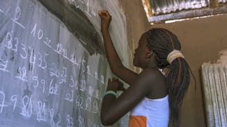 Guinee Bissau onderwijsproject toegang tot kwaliteitsonderwijs, meisje schrijft op het bord