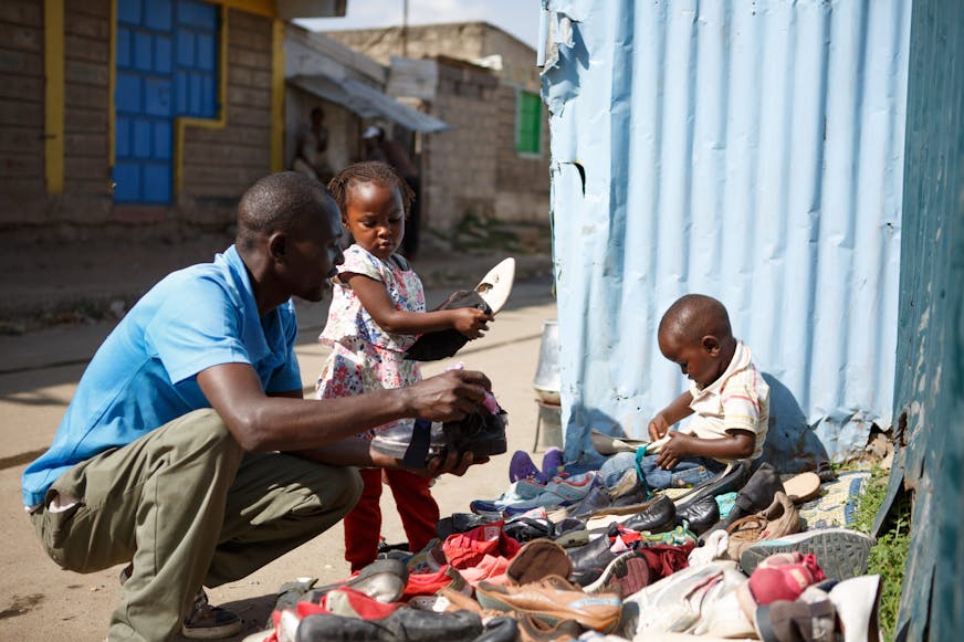 Antony kiest ervoor zijn kinderen zelf op te voeden, samen schikken ze de schoenen op het verkoopkleed