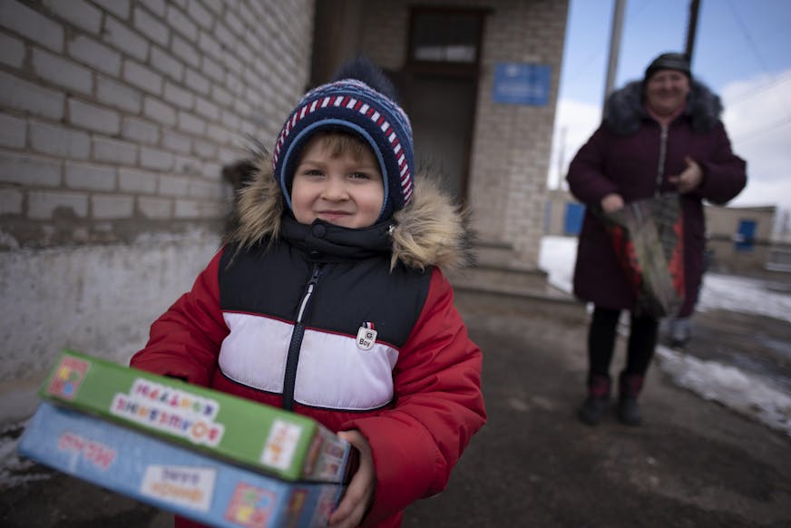 Jongen in Oekraïne met dozen in zijn handen