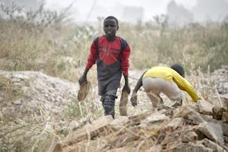 Kinderarbeid SOS Kinderdorpen - 2 jongens slepen met stenen in Nigeria