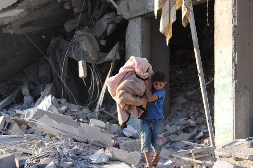 Kind dat beddengoed vasthoudt in Gaza