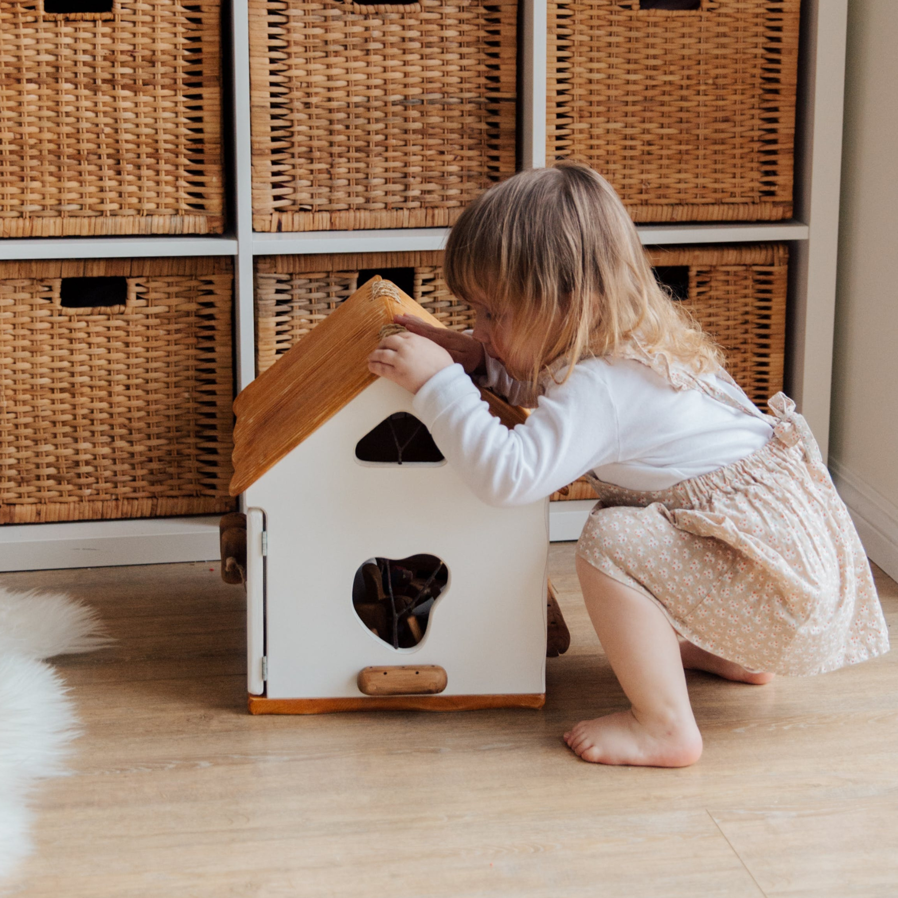 Meisje op hurken bij een speelhuisje