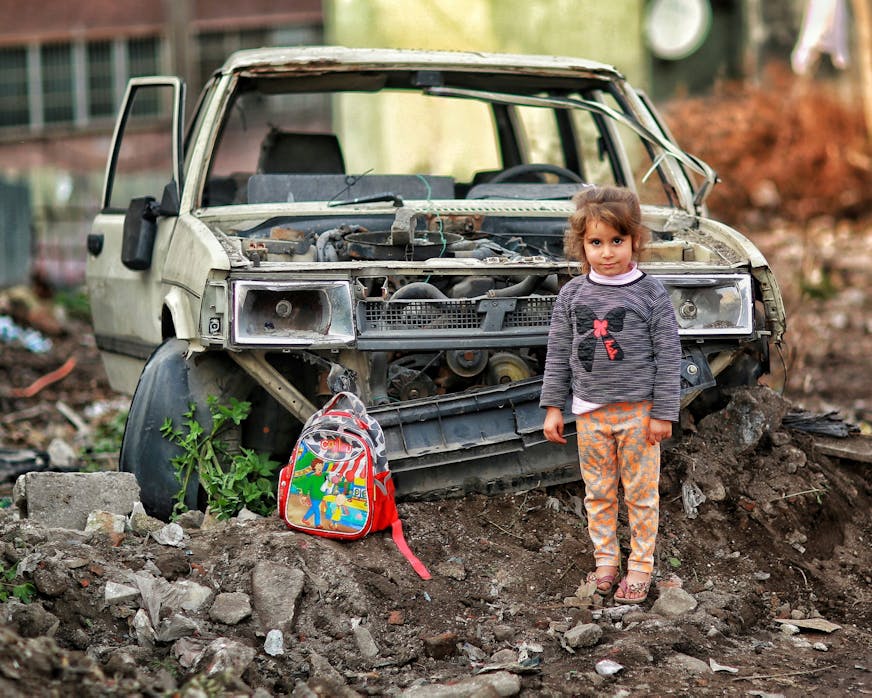 Girl in front of damaged car in Gaza, Palestina