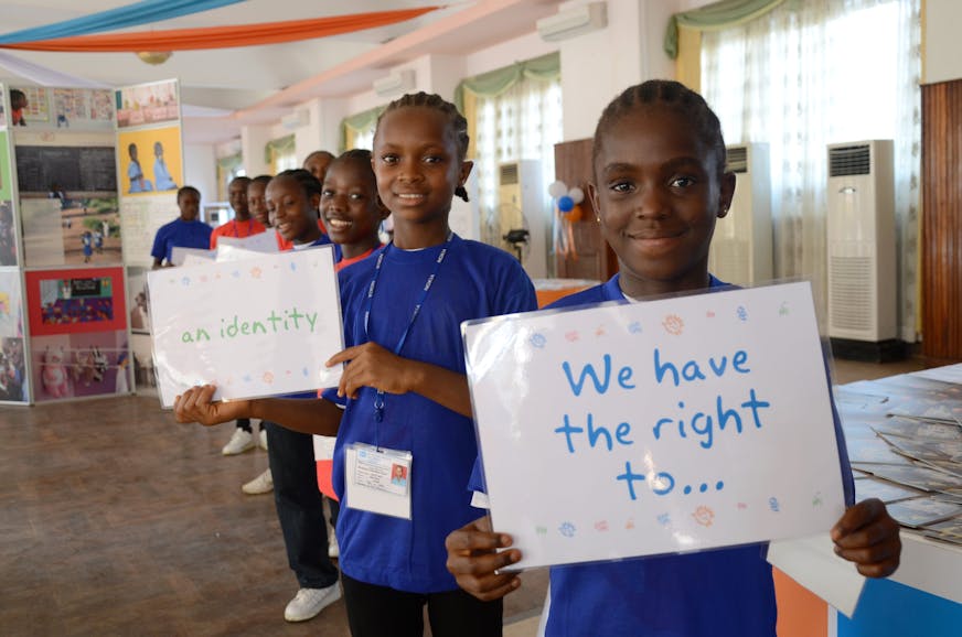 Kinderen in Liberië pleiten met borden voor hun kinderrechten, in het SOS Kinderdorp in Liberia, Juah Town. Op de borden staat: “We have the right to… an identity”