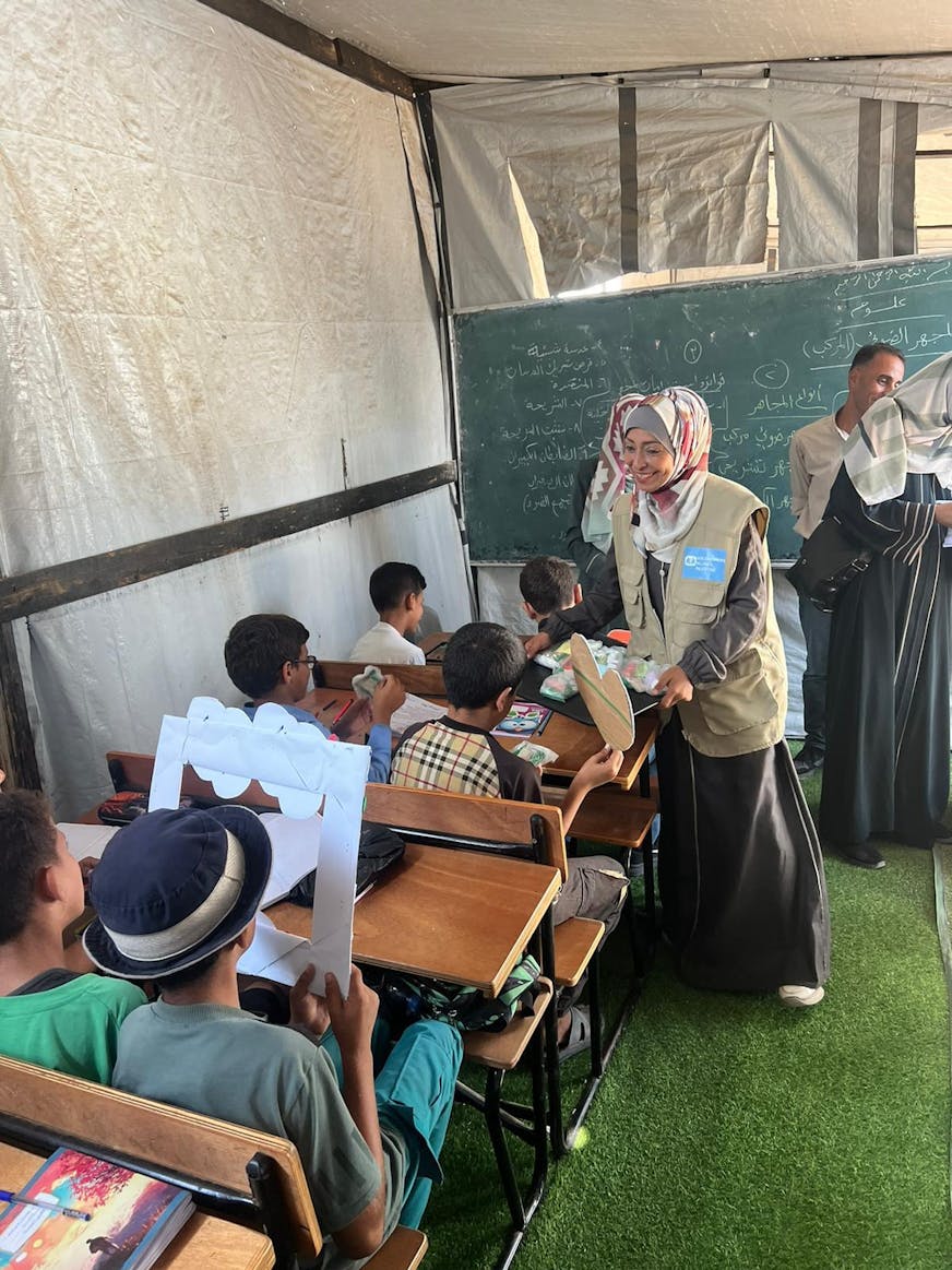 Lerares in Gaza met kinderen in schoolbanken