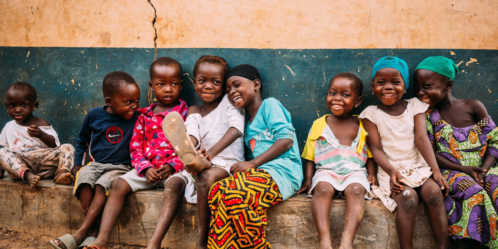 Kinderen in Ghana zitten op een rij naast elkaar