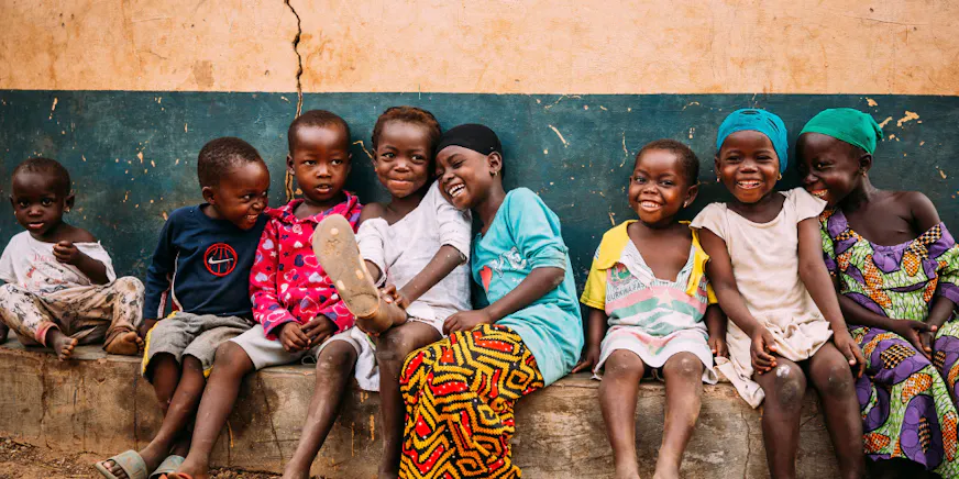 Kinderen in Ghana zitten op een rij naast elkaar
