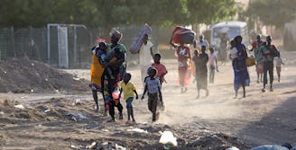 Families lopen in de puin van oorlogsgebied