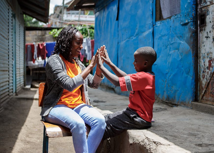 Volwassene en kind klappen tegen elkaars handen.