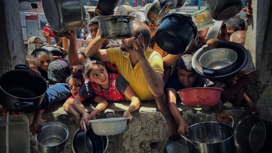 Hongerige kinderen en volwassenen in Gaza houden pannen vast