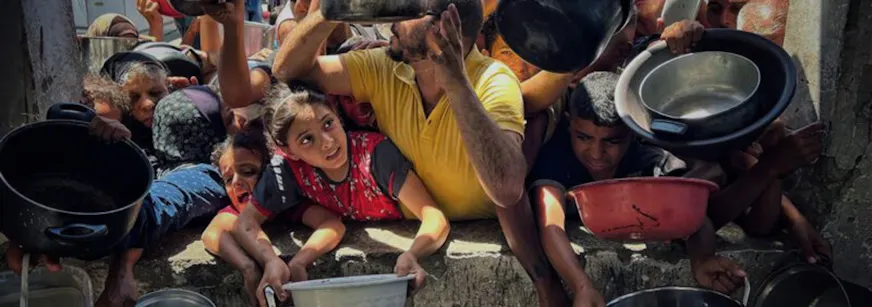 Kinderen en volwassenen in Gaza vragen om eten met pannen in hun handen.