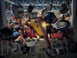 Kinderen en volwassenen in Gaza vragen om eten met pannen in hun handen.