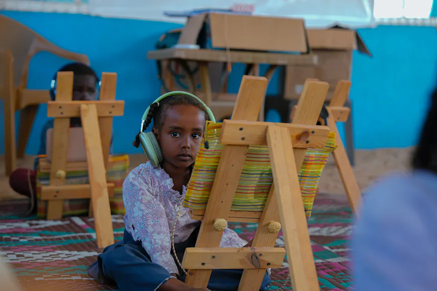 kind voor schilderezel in de klas in Soedan