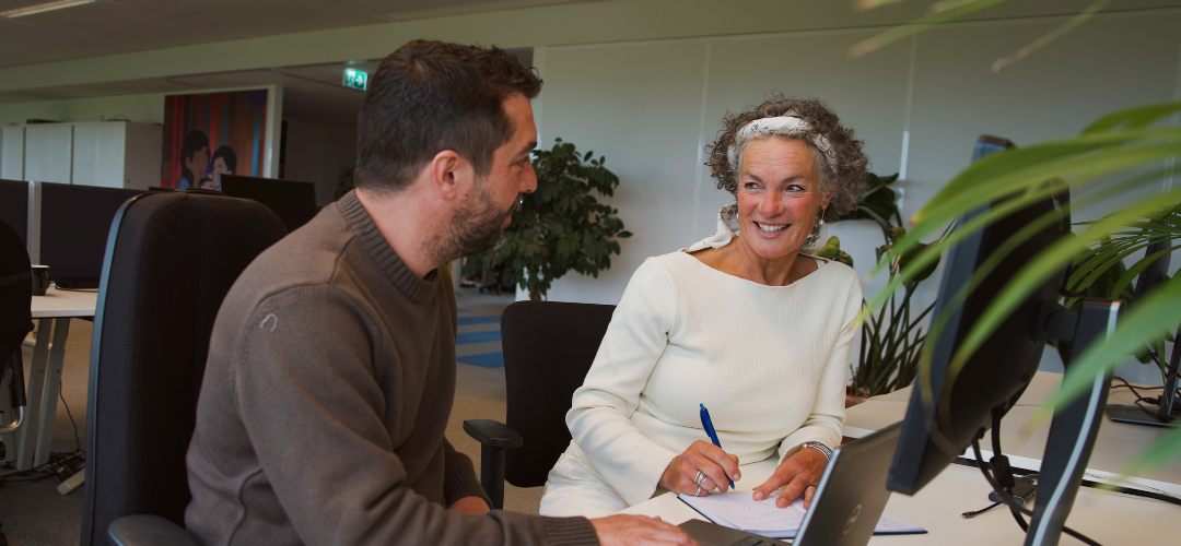 Man en vrouw zitten op kantoor voor laptop