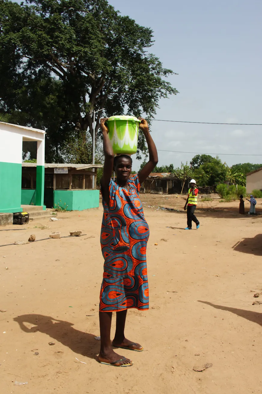 Dorpsbewoners halen schoon water bij het nieuwe waterpunt naast het gezondheidscentrum in Pelundo, Guinee-Bissau.